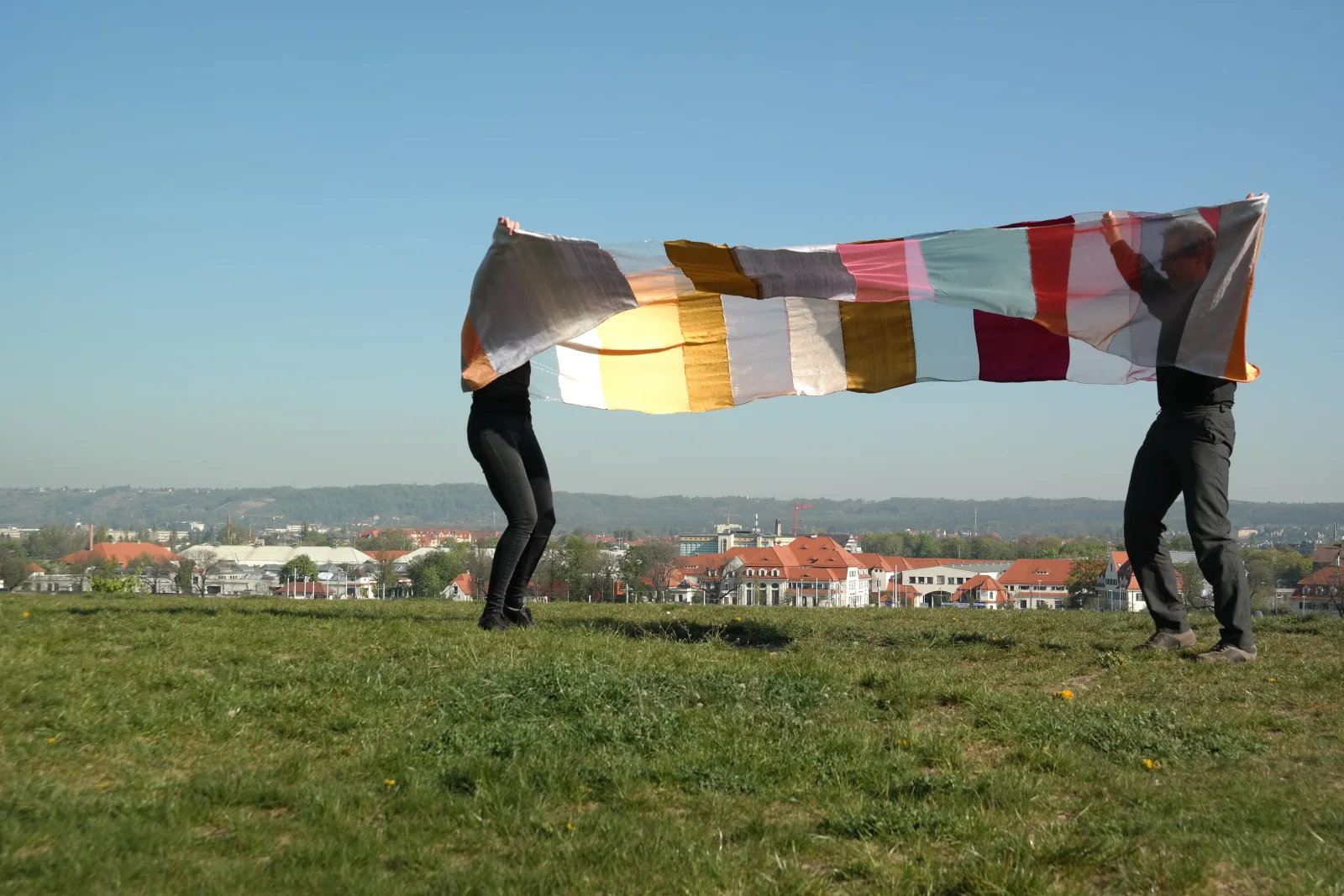360° NOSW — das Stoffband zwischen beiden Körpern weit aufgespannt, Blick über die Dächer