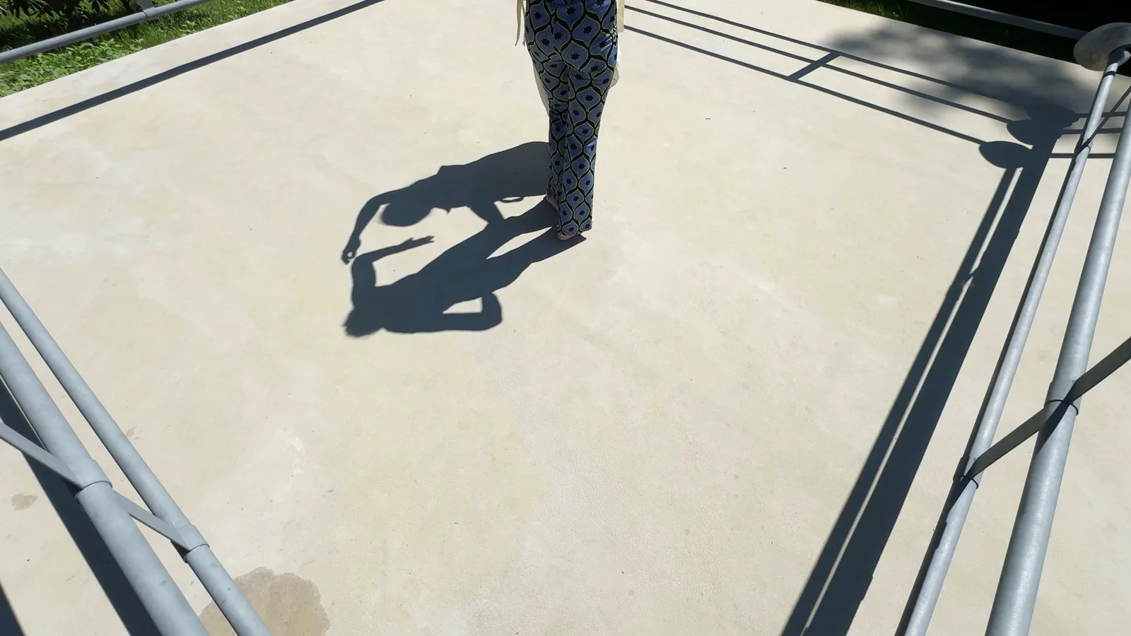 ALOKA · SHADOW — eine Figur am oberen Rand, ihr Schatten liegt quer auf der Fläche, Standbild