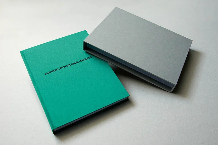 BRIEFMARKE, BILDENDE KUNST, LANDSCHAFT — das Künstlerbuch mit türkisem Handeinband und der Titelprägung, daneben der graue Schuber, 2014