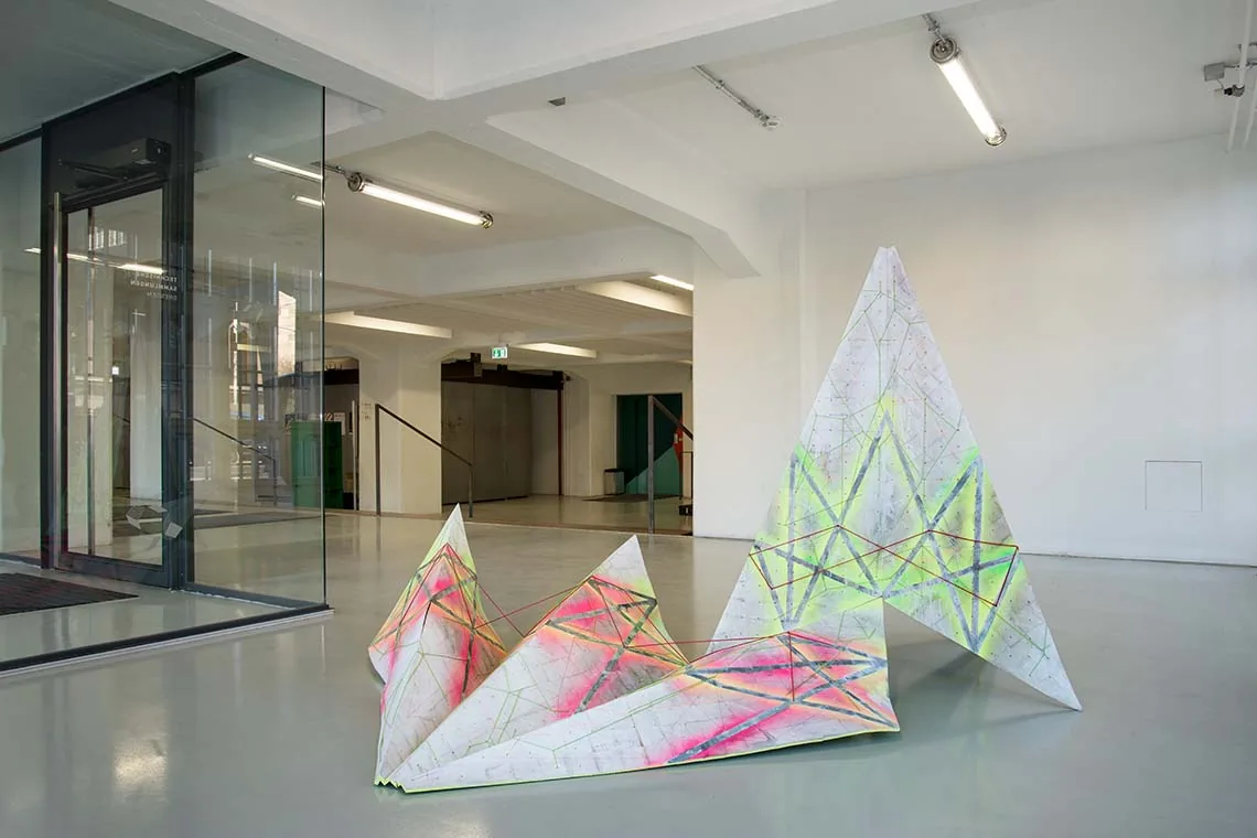 KRISTALL 20, ENTFALTET — die entfaltete Form im Ausstellungsraum, hinter einer Glaswand, die aufgerichtete Partie neben der leicht ansteigenden Faltung am Boden