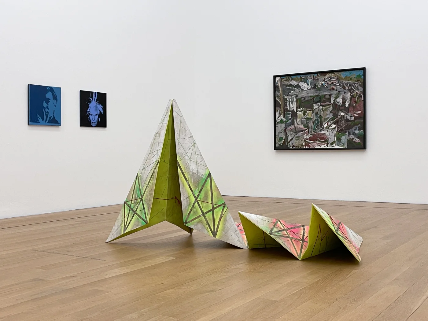 KRISTALL 20, ENTFALTET — die Arbeit in der aktuellen Präsentation im Museum Wiesbaden 2026, im Bereich Moderne und zeitgenössische Kunst; links an der Wand zwei Porträts nach Andy Warhol
