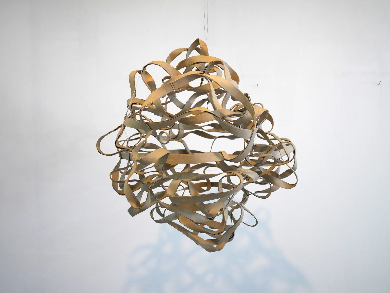 LOOPS — Wolke: hängende Form aus dicht verschlungenen Pappschlaufen, darunter ihr Schatten