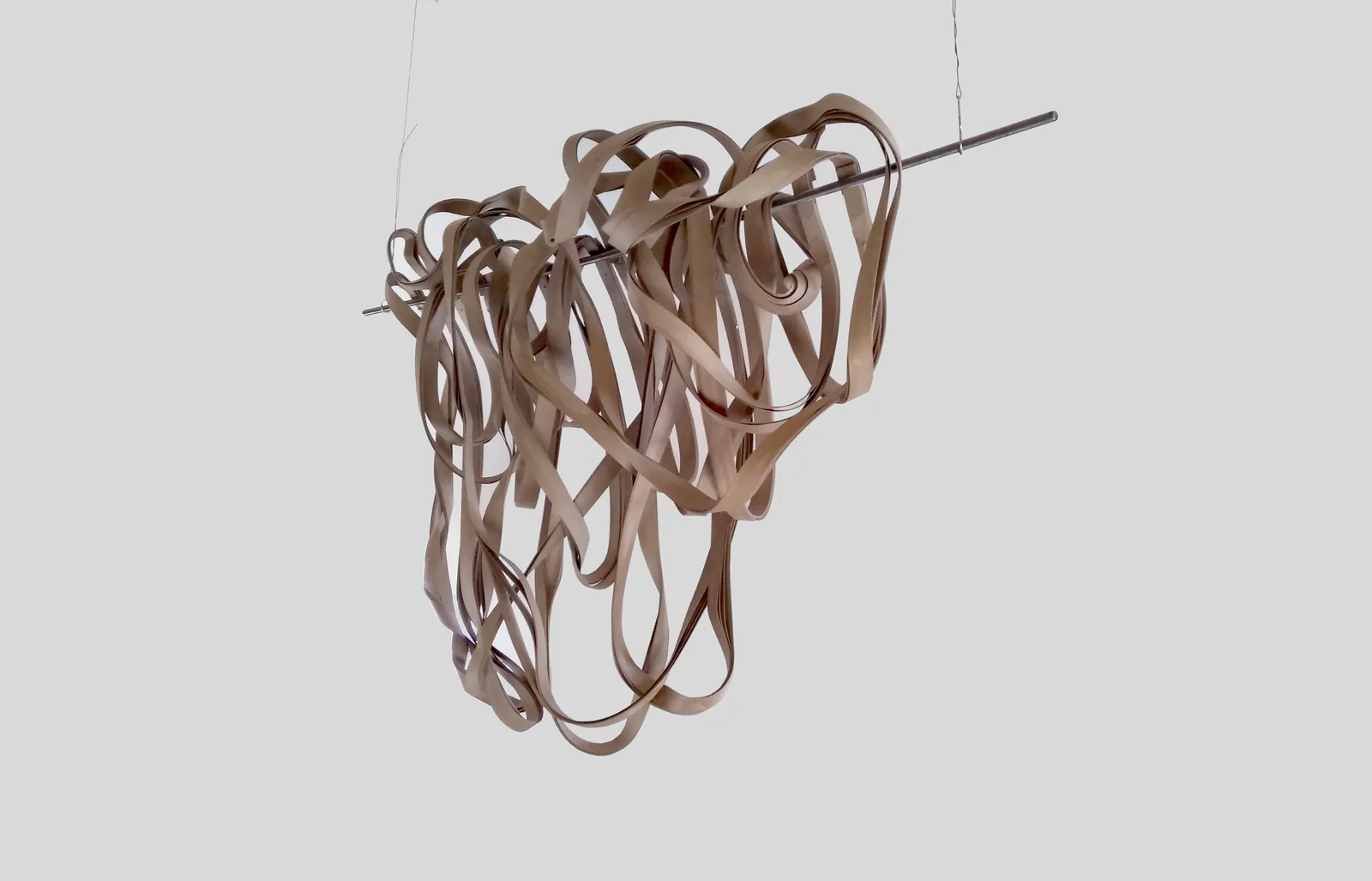 LOOPS — LOOP: braune Pappschlaufen hängen dicht gebündelt an einem Metallstab
