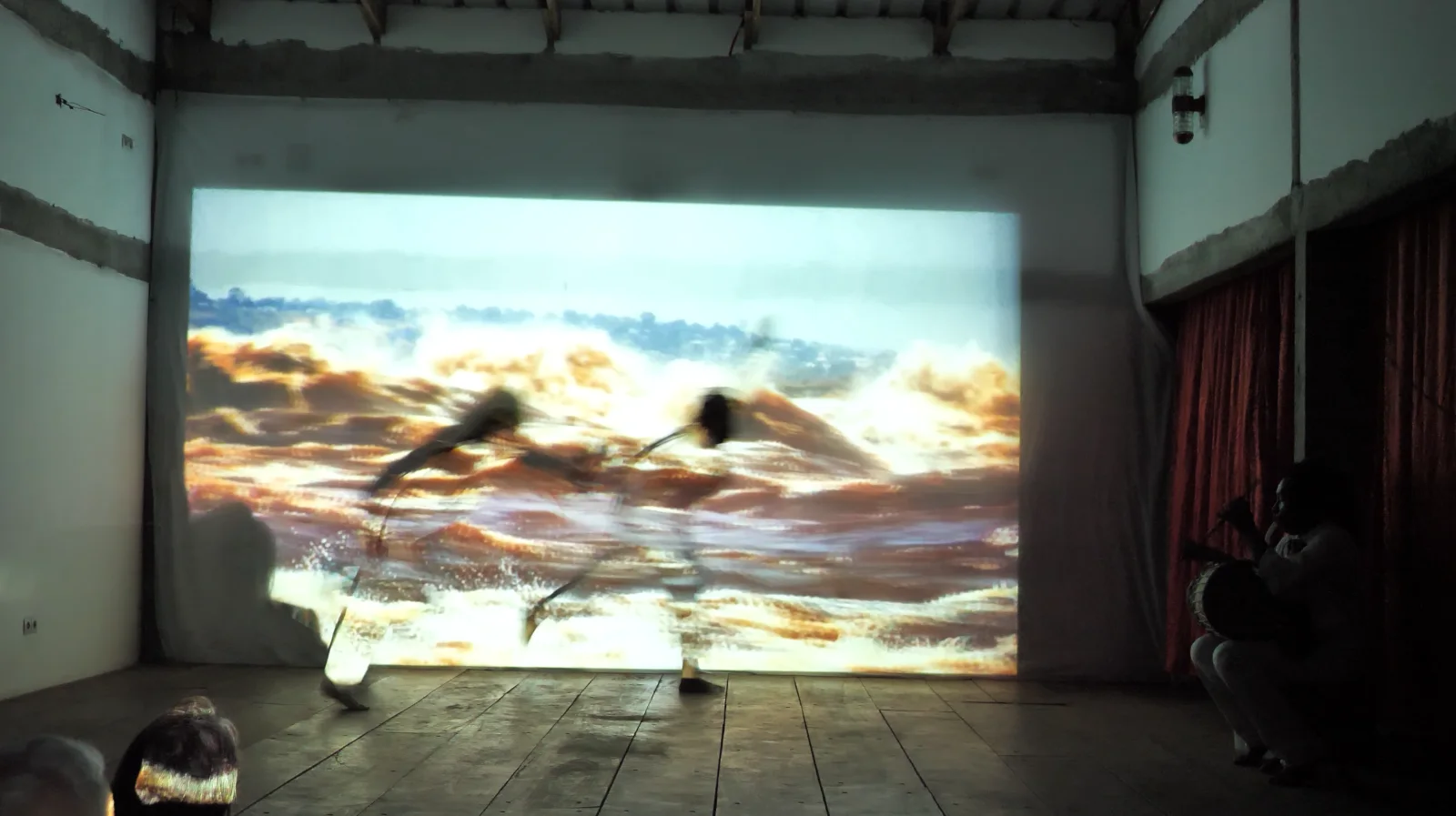 MAMBA — Live-Performance im Espace Kangou: Performende vor der Projektion eines tosenden Flusses; startet das Video