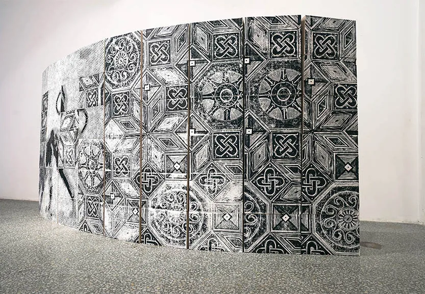 SPOLIA — die freistehende, leicht gebogene Mauer im Ausstellungsraum, schräg gesehen