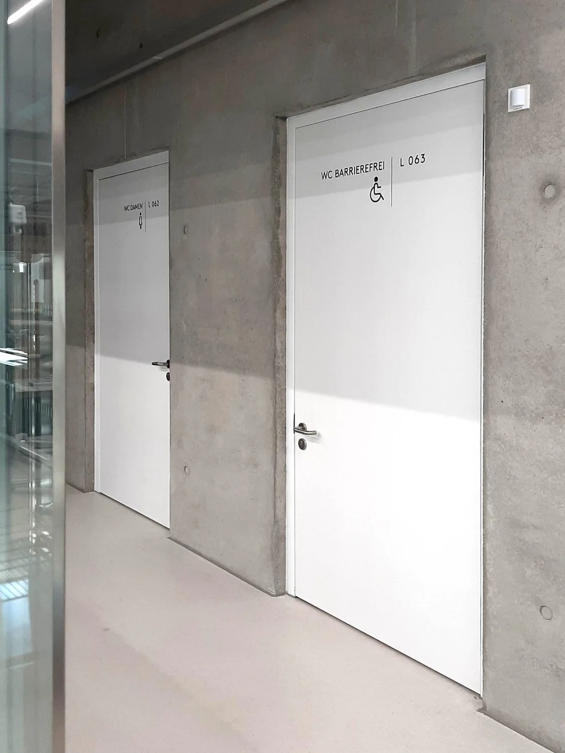 Türbeschriftung WC Barrierefrei L 063 und WC Damen L 062 im Sichtbeton-Flur, OTH Regensburg Neubau Architektur