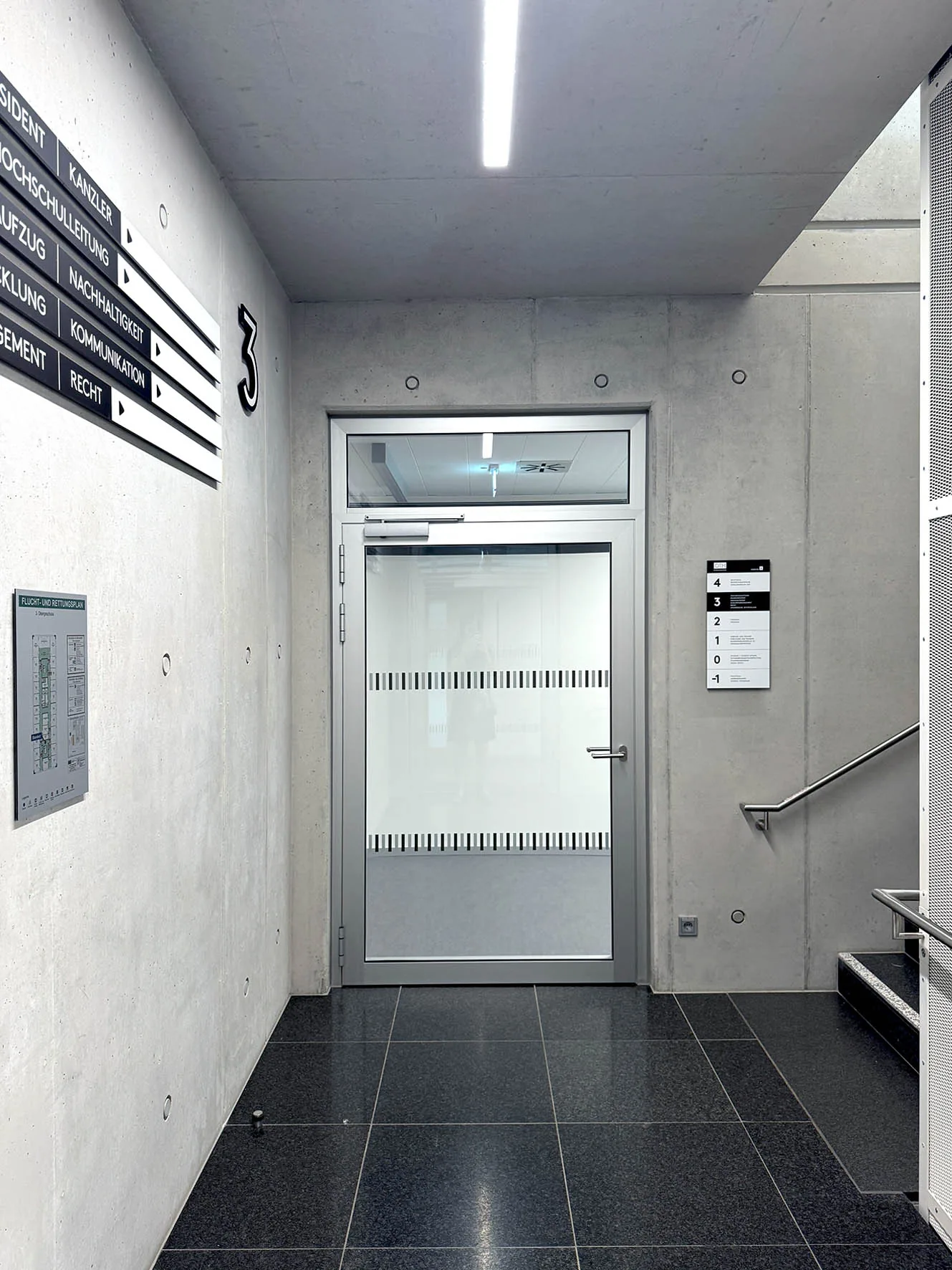 Flur mit großer Geschossnummer 3 und schwarz-weißen Richtungsschildern, Neubau Verwaltung OTH Regensburg