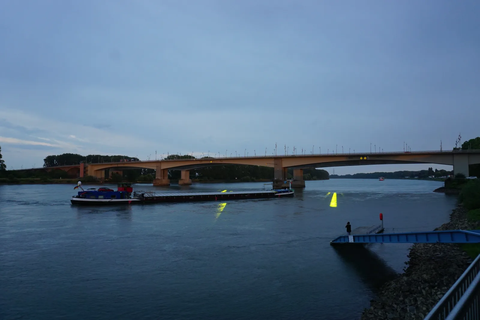 EINDUTZEND — Panorama des Rheinufers mit der ganzen Brücke, Schiff und Lichtspuren in der Abenddämmerung, Worms