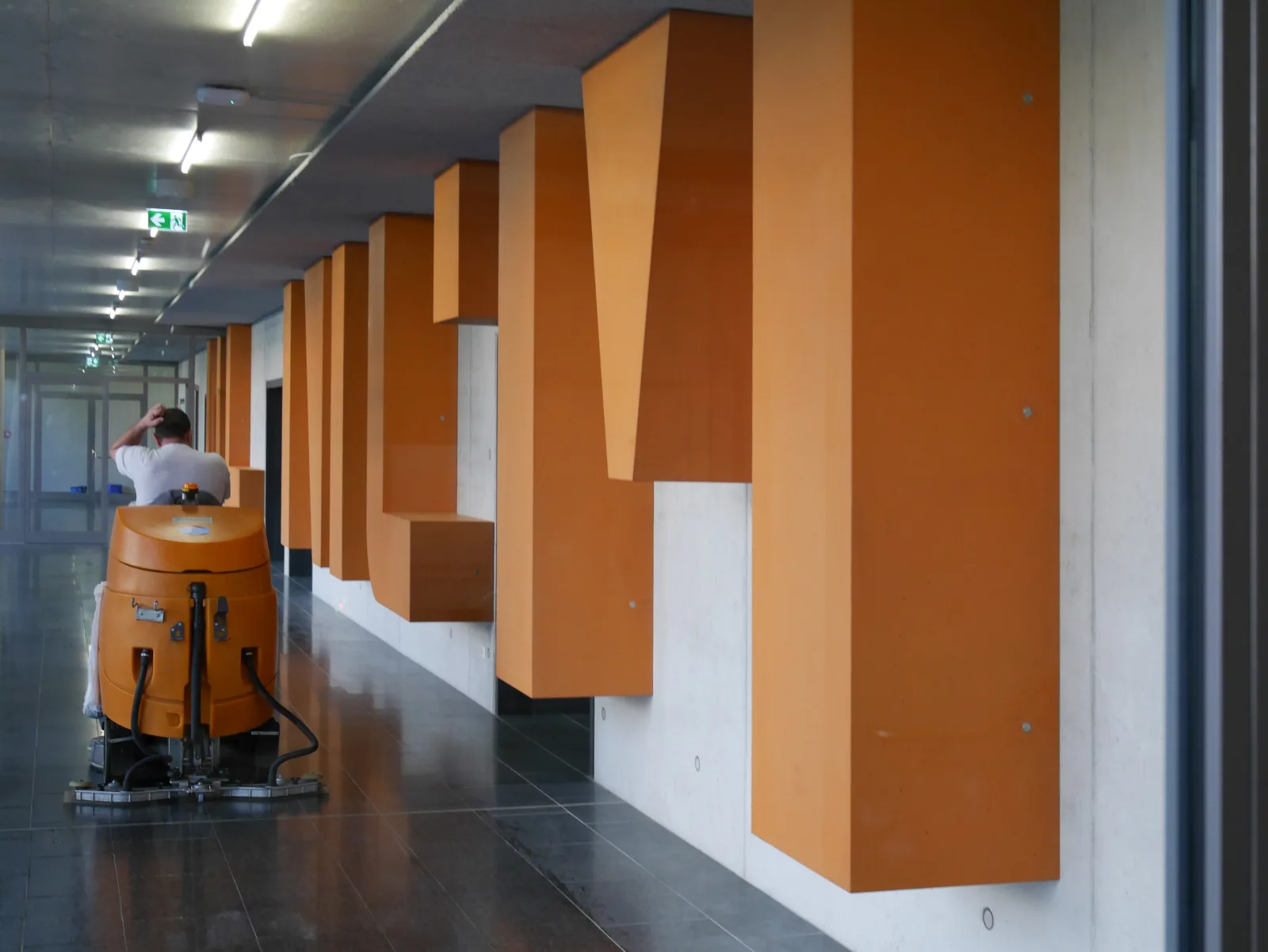 IN_GENIUM — die raumhohen orangen Buchstaben im Flur der OTH Regensburg, während der Bodenreinigung