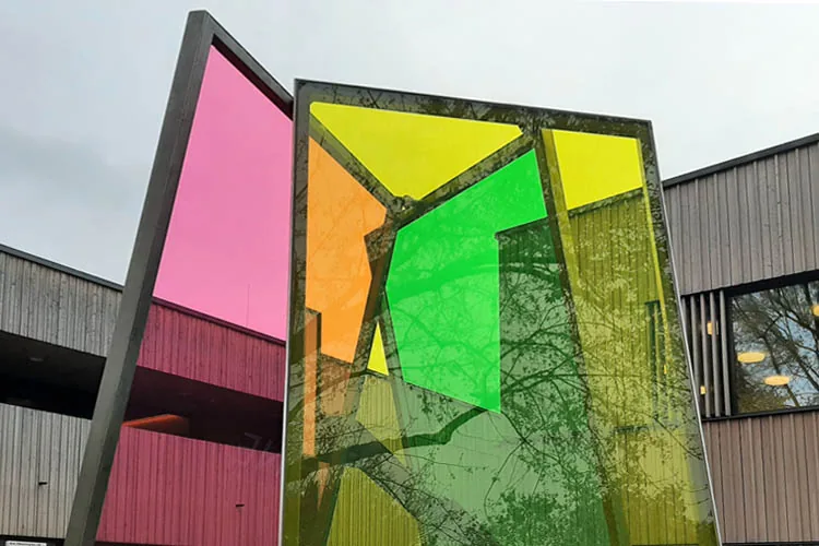 TIPI — frontaler Blick durch die farbigen Glasflächen, die Überlappung in Gelb, Magenta und Cyan erzeugt neue Farbmischungen, Bürgerhaus und Kita Mainz-Finthen, 2023